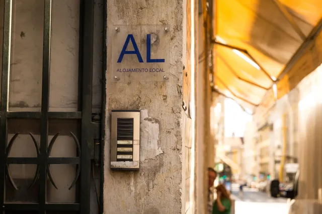 Placa AL junto à porta de um alojamento local