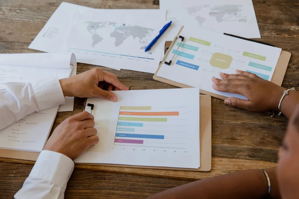 Reunião de trabalho com documentos e gráficos sobre a mesa