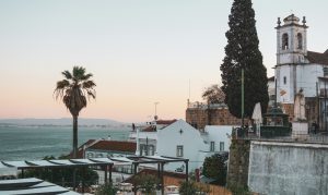 Vista sobre telhados e o rio Tejo em Lisboa, cidade que cobra taxa municipal turística